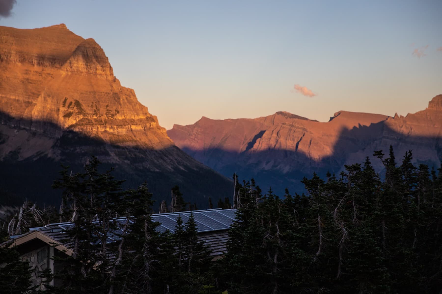 Solar panels set against a mountain landscape at sunrise